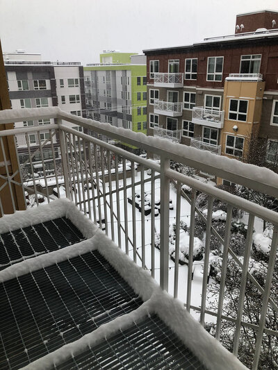 Balcony of apartment with snow in the background.