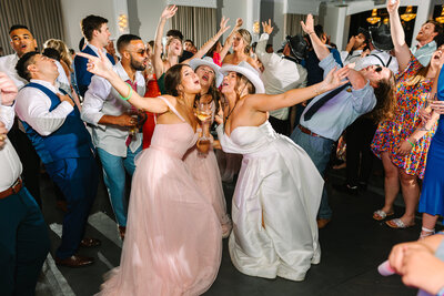 Bride and wedding guests singing and dancing together at reception
