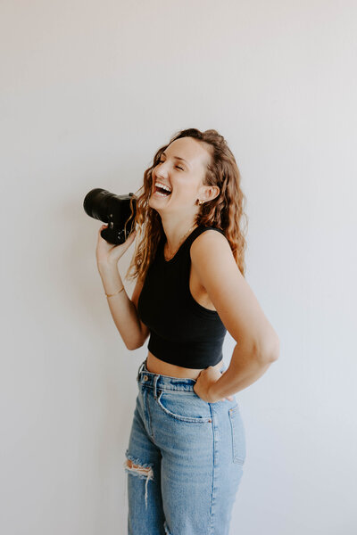 woman laughing holding a camera