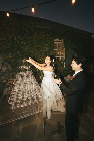 bride and groom pour champagne tower