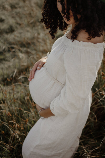 Zwangerschaps shoot. Witte jurk in een groen veld. 