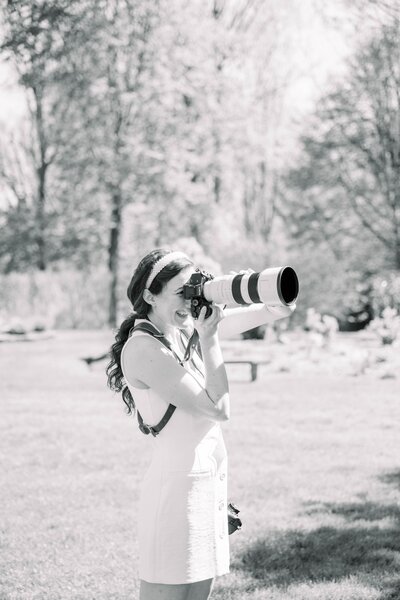 black and white photo of new england wedding photographer meghan lynch holding her sony up to her eye