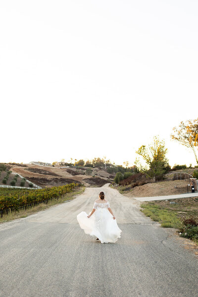 bride running from camera at sunset