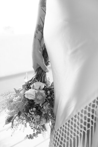 bride holding her dress and bouquet