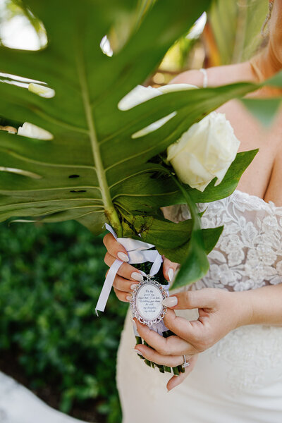 Kelly holding a white rose bouquet with tropical greenery at her Islamorada wedding, photographed by Claudia Amalia.