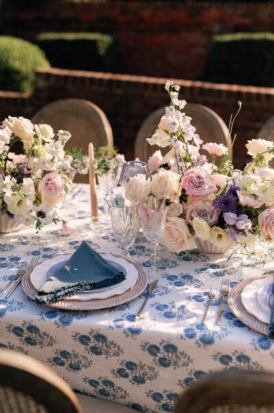 a pink and white floral centerpiece on a blue tablecloth