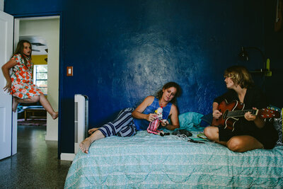 Family of three hanging out in a Blue Bedroom