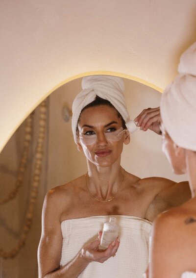 A wooden stick drips thick, golden wax against a light gray textured background.