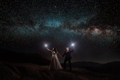 A bride and groom clink beer cans while taking in an epic mountain view from a forest service road in Mammoth Lakes. 
