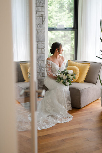 La mariée pose avec son bouquet de fleurs lors de la préparation pour son mariage urbain de luxe dans les Laurentides.