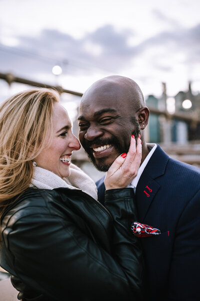 Mixed race engaged couple on the Brooklyn Bridge in New York. 