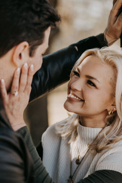 Rachel smiling up at Blaine while gently caressing his face during their engagement session in Oxford, Mississippi.