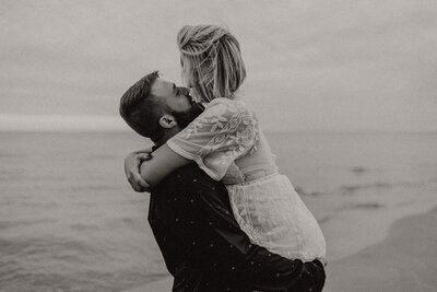 black and white image couple embracing on beach