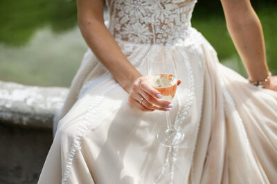 Bride holding a glass of champagne in a lace wedding dress