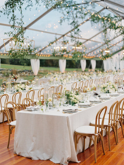 Outdoor wedding tablescape with fresh oysters, crystal glassware and a green & white floral arrangement