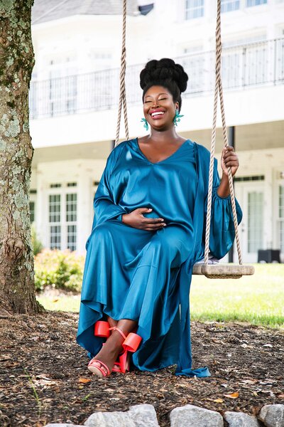 photo of smiling black pregnant woman in swing at White Fallow Estate in Georgia