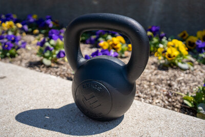 a kettlebell sitting in front of flowers, used for online strength coaching