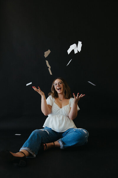 Founder of Bubbly Bride Planning, Rachel, throws her business cards during a branding shoot.