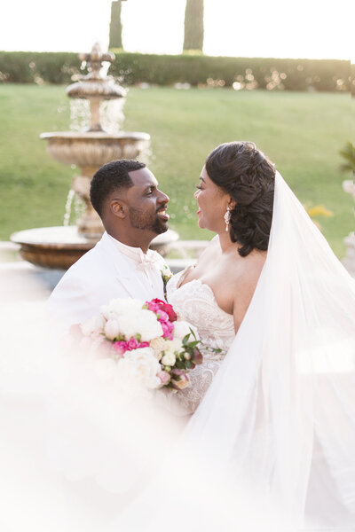 a bride and groom smile together at their grand island mansion wedding