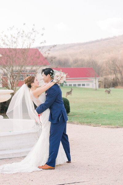 Bride and groom by the pool deck at the Sagamore Pendry  hotel with the Baltimore skyline in the background.