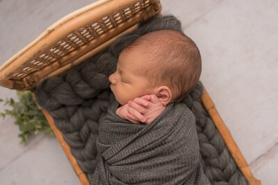 Baby girl in floral fall bonnet with burnt orange blanket