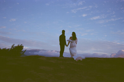 bride and groom embrace in front of their family home for a backyard wedding