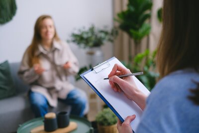 Therapist taking notes during in-person Christian therapy session in Amarillo, TX.