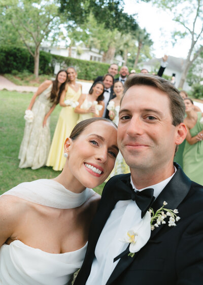 Groom sitting on a chair while bride sits on his leg holding his hand