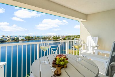 Beautiful lakefront balcony with tall Adirondack chairs and table set