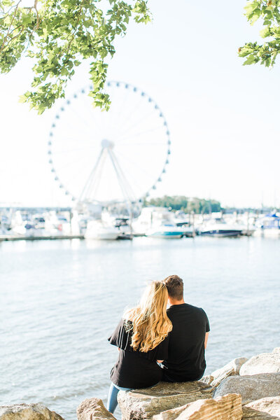 couple sitting on national harbor pier
