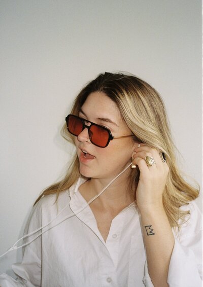 Emily C holding earbud to hear ear for music classes