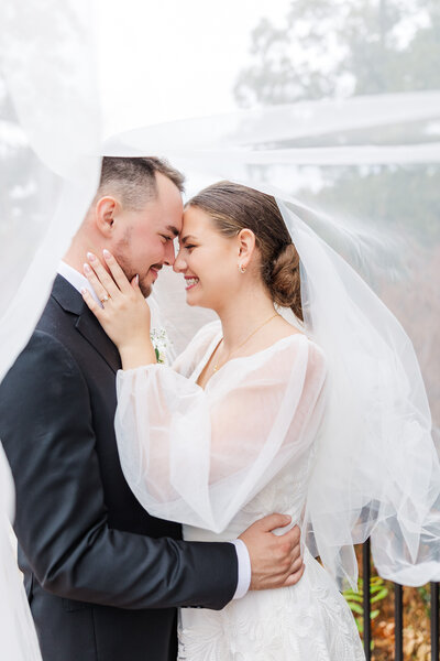 bride smiling while touching her groom on the face