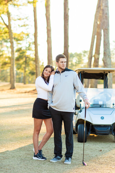 engaged couple posing on a golf course