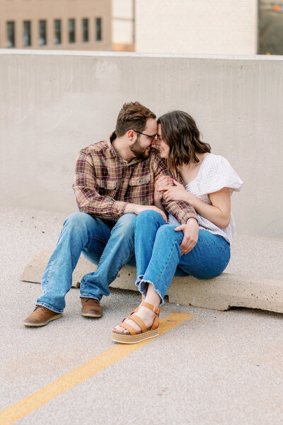 couple cuddles close together on a rooftop parking garage in downtown amarillo texas