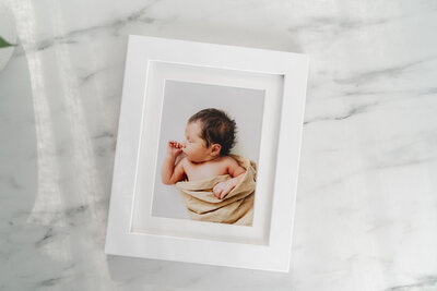 A framed photograph of a newborn baby.