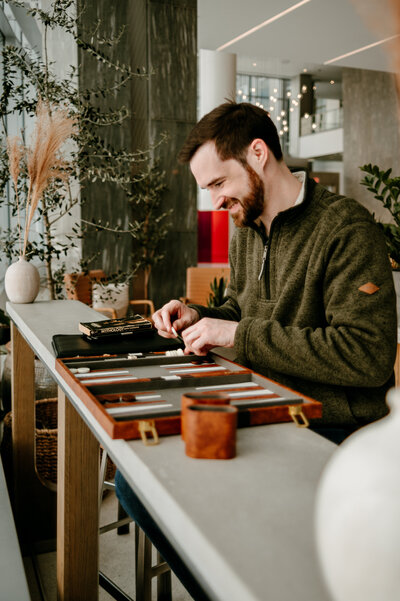 Behind-the-scenes moment of a photographer capturing a man’s natural smile during a dating profile photo session in Minneapolis.