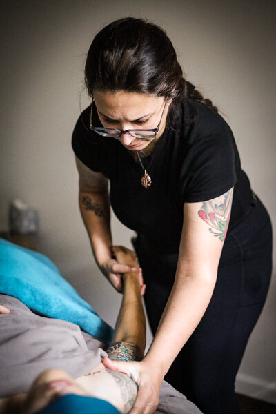 Massage Therapist stretching and healing client through arm massage