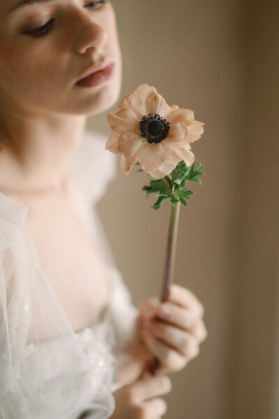 A stunning bridal portrait taken in Dallas-Fort Worth, featuring a bride in a flowing gown, holding a lush, garden-inspired bouquet with warm floral tones