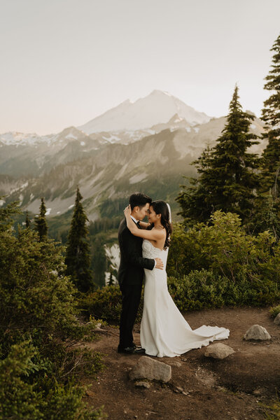 Elopement couple taking photos in gown and suit at sunset
