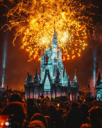 A magical view of the Disney castle illuminated against the night sky, surrounded by colorful fireworks bursting in the air. This enchanting scene captures the wonder and excitement that vacation fundraising for charities can provide, creating unforgettable experiences.