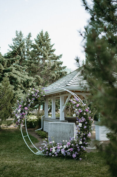 Outdoor ceremony with floral arch in the garden at the Inn on Officer's Garden in Calgary