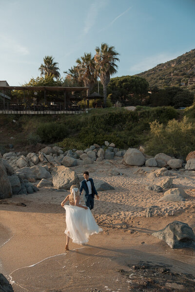 groom twirling his bride next to a bridge