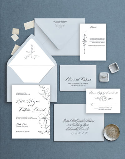 Flat lay of a blue and white wedding invitation suite