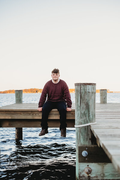 Teen sitting on pier at the water in Annapolis Maryland for Senior photos.