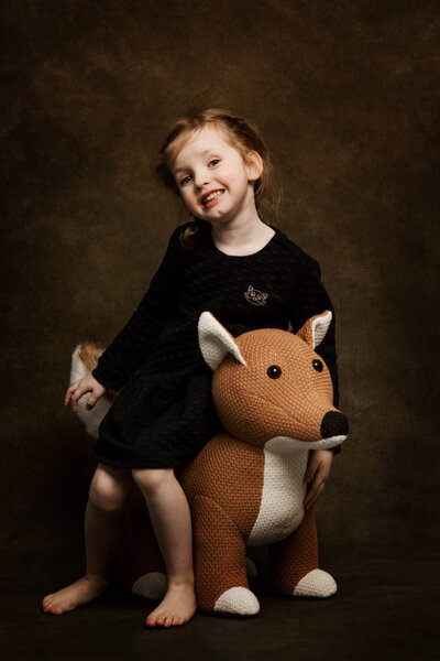 Ein Mädchen beim Foto Shooting  mit einem Spielzeug-Fuchs im tageslichtstudio Aachen