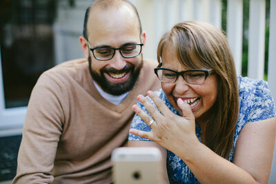 Happy Engaged Couple calling family to let them know they are Engaged