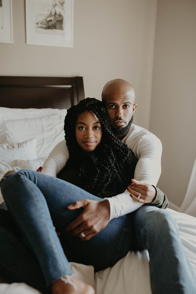 A couple laying comfortably in a bed.