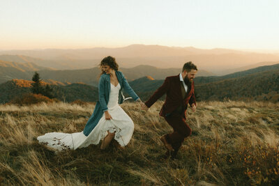 bride and groom walking up aisle while photographer takes picture eloping in the north carolina mountains at roan mountain