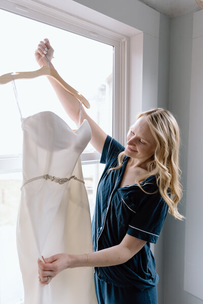 Bride holding up a bouquet of flowers during a beach elopement in Michigan.