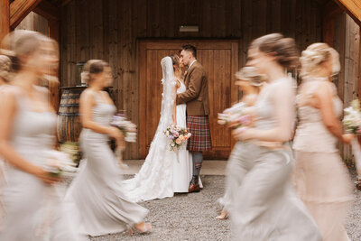 Bride and bridesmaids laughing under confetti at aswanley wedding venue